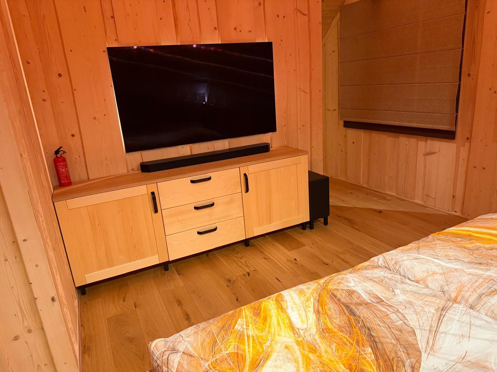 Nízká komoda pod televizí v podkrovní ložnici