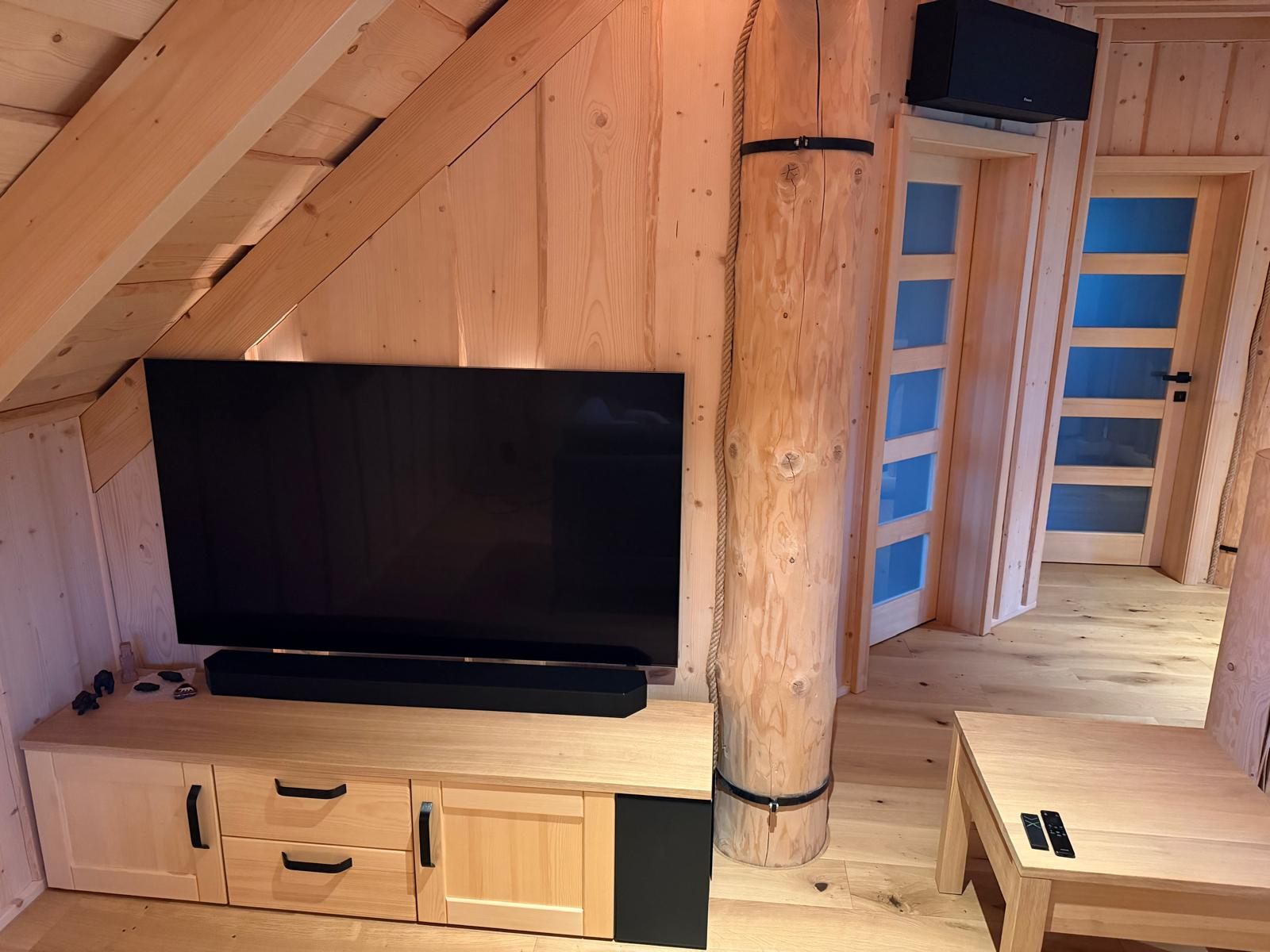 Obývací stěna a komoda pod televizí v podkroví srubu